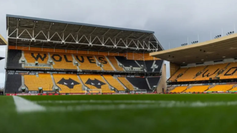 Orange and black seating forming a Wolf can be seen on one side of the stadium with more orange seating in a neighbouring stand. 