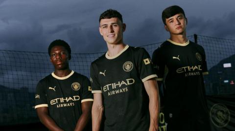 Phil Foden, Abdukodir Khusanov and Ryan McAidoo modelling Manchester City's new away kit