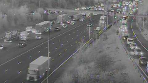 A black and white motorway camera image of traffic building up