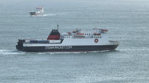 The Ben-My-Chree, which is painted in the Isle of Man Steam Packet Company's black, white and red livery, sailing across Douglas Bay, with freight MV Arrow in the background heading in the opposite direction.