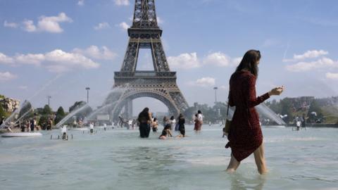 People cool down in the fountains of Trocadero, across from the Eiffel Tower