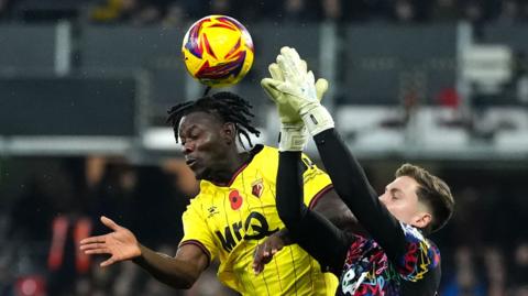 Watford's Kwadwo Baah (left) and Oxford United goalkeeper Jamie Cumming battle for the ball