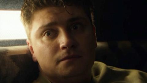 Man sits in the semi dark looking worried