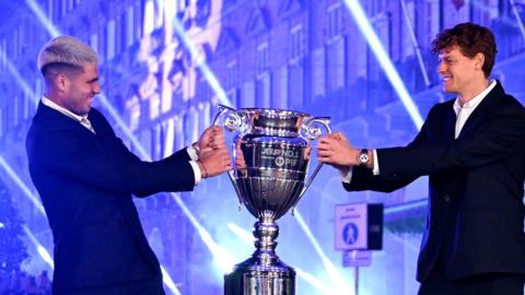 Carlos Alcaraz and Jannik Sinner pose with the ATP year-end number one trophy