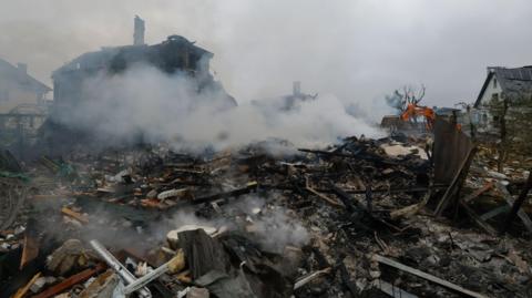 Ukrainian rescuers work at the site of a residential area struck by a rocket as a result of an overnight strike in a village near Kyiv, Ukraine.