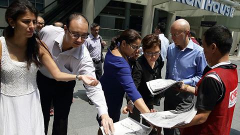 A man distributes a free newspaper following the death of former Prime Minister Lee Kuan Yew. March 23, 2015, Singapore.