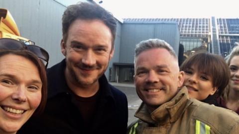 Russell Watson with firefighter outside the SEC