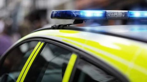 Stock image of a police car with sirens on