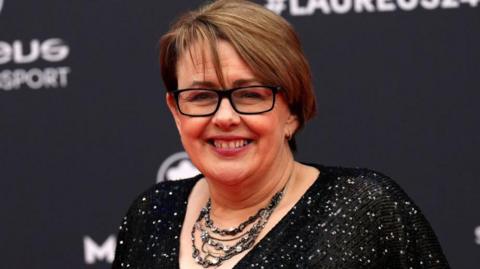 Tanni Grey-Thompson smiles on a red carpet 