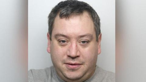 Graham Dowling looking at the camera with his mouth slightly open. He has short, greying hair and slight stubble.