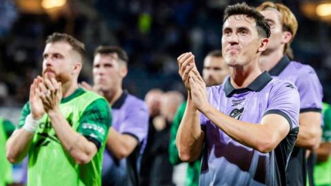 Hibs midfielder Jamie McGrath applauds visiting fans in Belgium