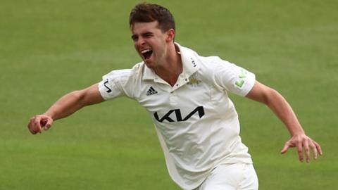 Tom Lawes celebrates taking one of his four wickets