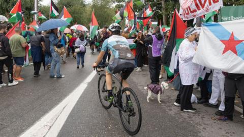 People gather at Alto de San Cosme to protest the presence of the Israel-Premier Tech team