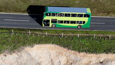 A bus on a road close to a cliff edge