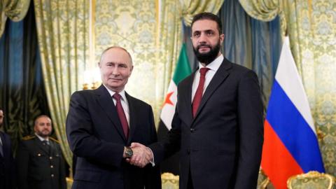 Vladimir Putin (L) shakes hands with Ahmed al-Sharaa (R) in Moscow