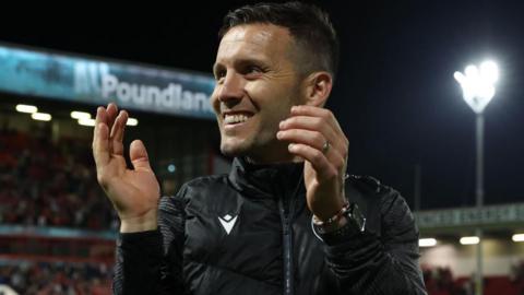 Walsall boss Mat Sadler smiles and claps the fans after a night game
