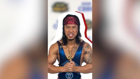 A man in a blue unitard and red bandana clenches his fists.