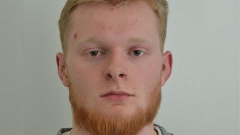Custody image of Jordan Richardson. He has short light-coloured hair and a ginger beard. He is looking directly at the camera.
