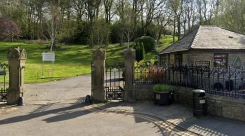 The front of Rawtenstall Cemetery surrounded by black railings and an ornate entrance