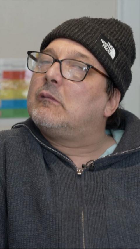 Head and shoulders image of man wearing black hat and fleece. He also has glasses on.