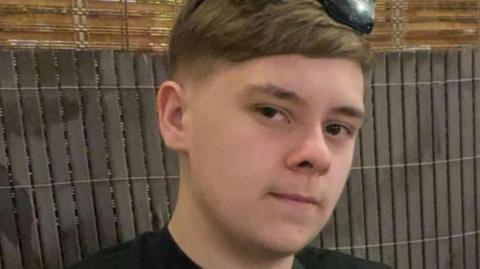 Harvey Willgoose, a teenager in a black T-shirt, looks at the camera