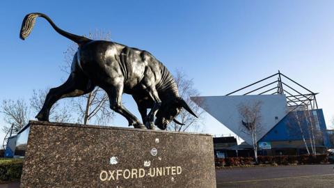 A general view of the outside of Oxford United's stadium with a statue of an Ox in the foreground