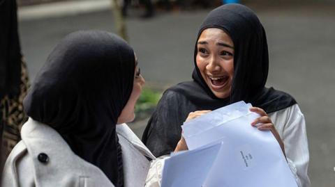 Students react after receiving their GCSE results