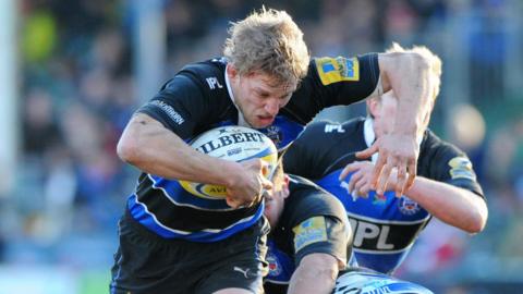 Image of Lewis Moody mid run on the rugby pitch. He's wearing the Blue and Black rugby kit and running with the ball. 