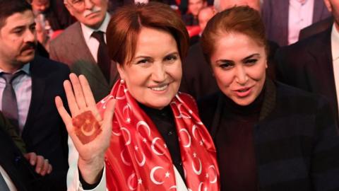 Meral Aksener (L) of the MHP shows her hand bearing a Turkish flag as she attends a No campaign meeting in Istanbul