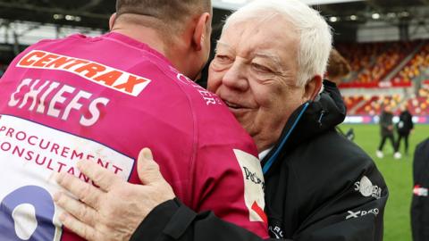 Tony Rowe hugs an Exeter player