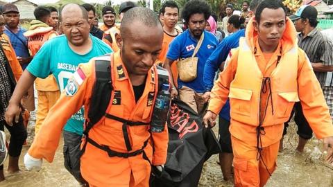 Rescuers carry body of victim