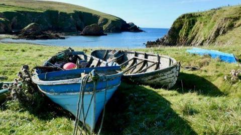 Traditional Shetland boats now decaying in their noosts at the Peerie Voe, Spiggie in Shetland’s South Mainland