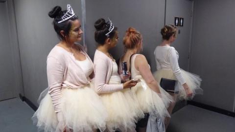 Ballerinas waiting in a queue for the loo