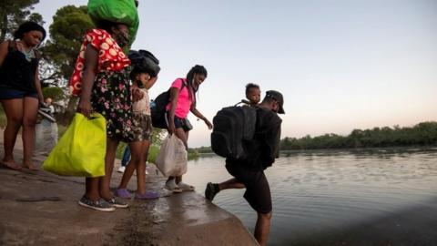 Migrants cross the Rio Grande on the US - Mexico border