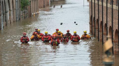 Members of the Mountain Rescue teams wade through floodwater in Skeldergate, York, on 28 December 2015