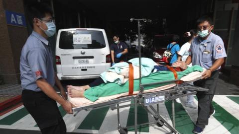 Hospital staff and rescuers evacuate affected hospital patients after a fire broke out at the Taipei Hospital in Hsinchuang, New Taipei City, Taiwan