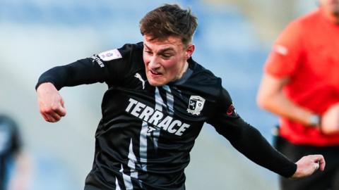 Barrow's Robbie Gotts has a shot against Colchester United