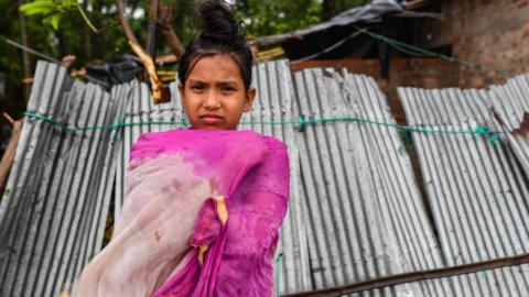 A girl in front of her broken house at on the outskirts of Teknaf in Bangladesh