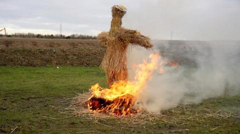 Straw effigy of a bear burning at Whittlesey festival.