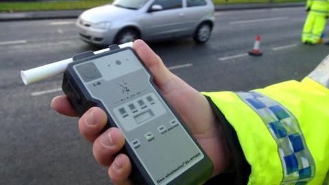 Officer holding a breathalyzer