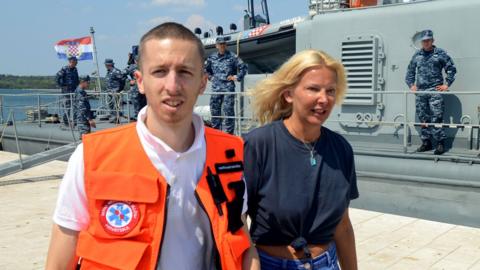 Kay Longstaff exits Croatia coast guard ship in Pula with medic