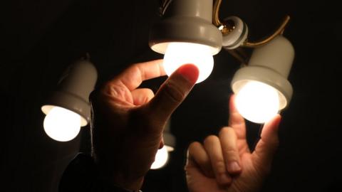 A person changes a light bulb, the day on which the price of light beats an all-time record by reaching 124.45 euros per megawatt hour, on August 30, 2021, in Madrid, Spain.