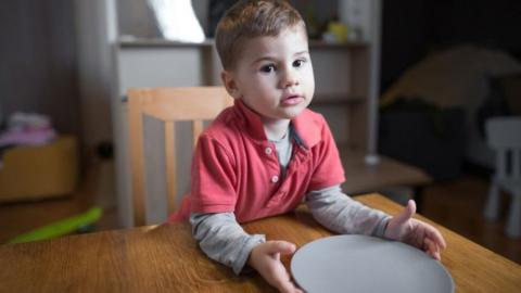 A child holding out a plate