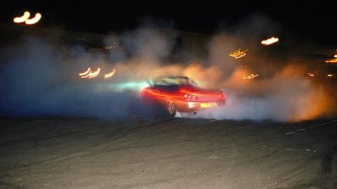 Boy Racers, wheel spinning the car to make smoke, Southend.