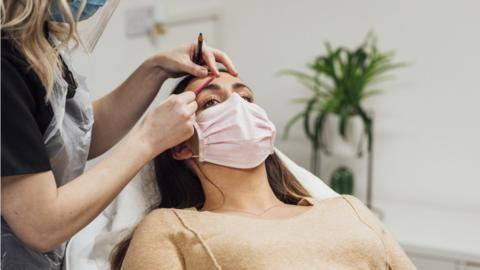 Woman receiving an eyebrow treatment.