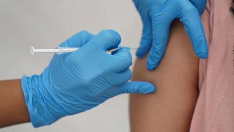 a person receiving a Covid-19 jab