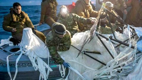 Navy personnel recovering balloon