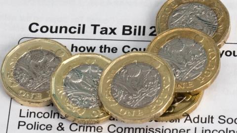 Council tax bill with pound coins on it