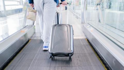 A passenger wheeling a bag at an airport