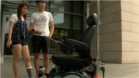 Passengers wait for a driverless taxi